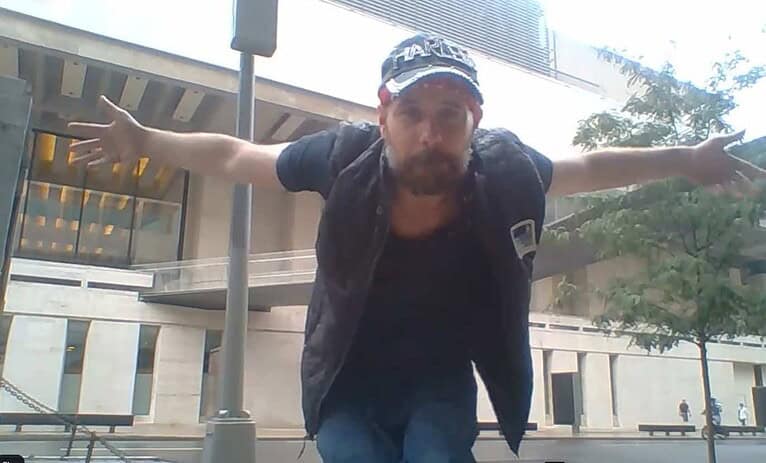 Bold and adventurous man with outstretched arms outdoors.